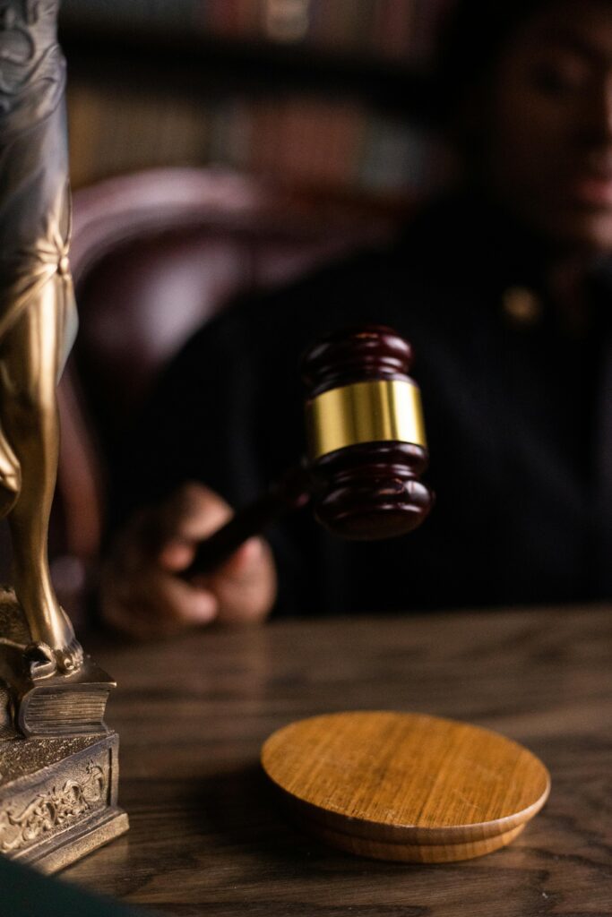 Close-up of a judge holding a gavel, symbolizing justice and law in a courtroom setting.